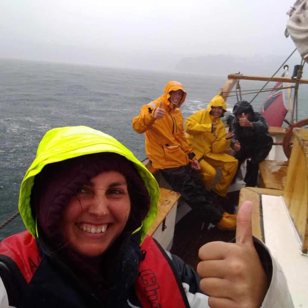 Jess sailing in the rain, thumbs up!