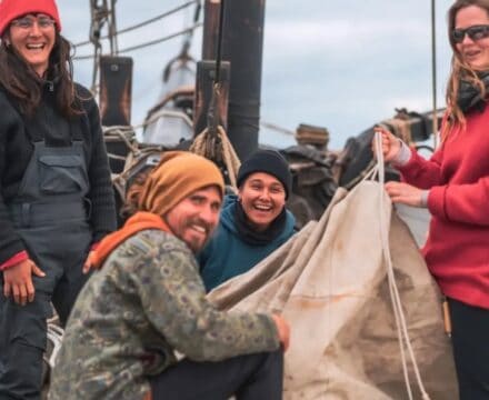 Grayhound crew setting sails, smiling at the camera.